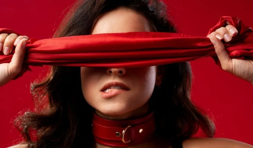 Une femme avec un bandeau rouge devant les yeux